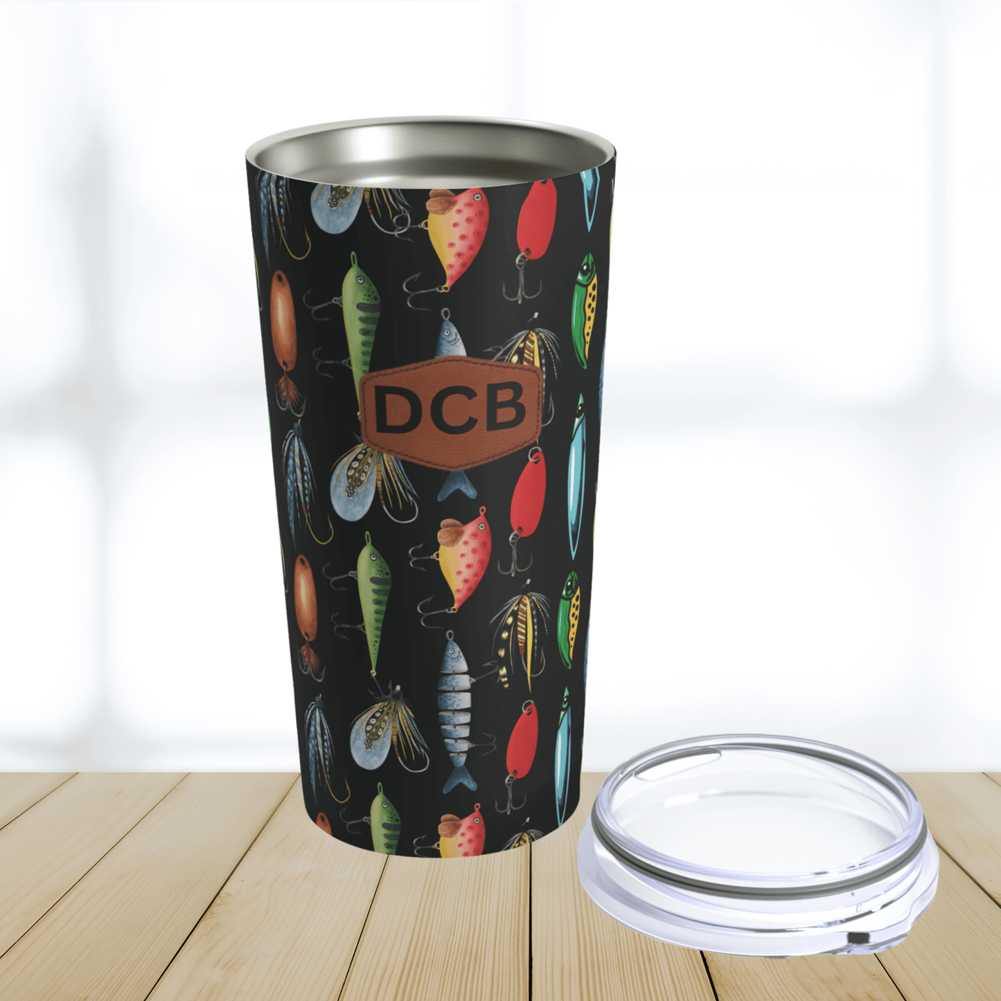 OUr fishing lure design travel tumbler is custom made and the monogrammed options has a brown leather print patch with up to three initals.