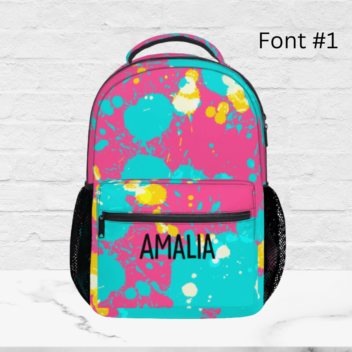 Our custom pink splatter backpack for kids shown with font one. This colorful backpack is sure to please the picky kid.