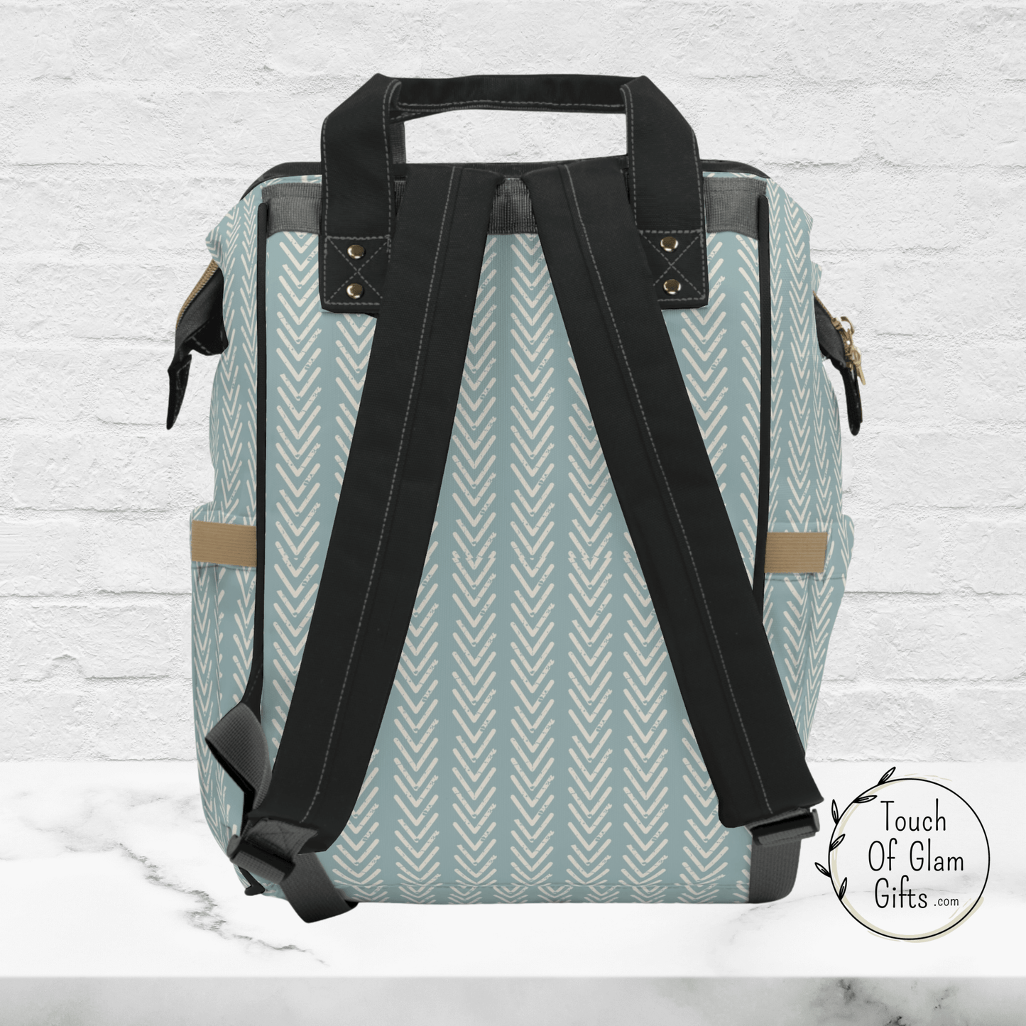 The back side of our boho sage green diaper baby bag shows the boho print all over and black adjustable straps for a comfortable backpack.