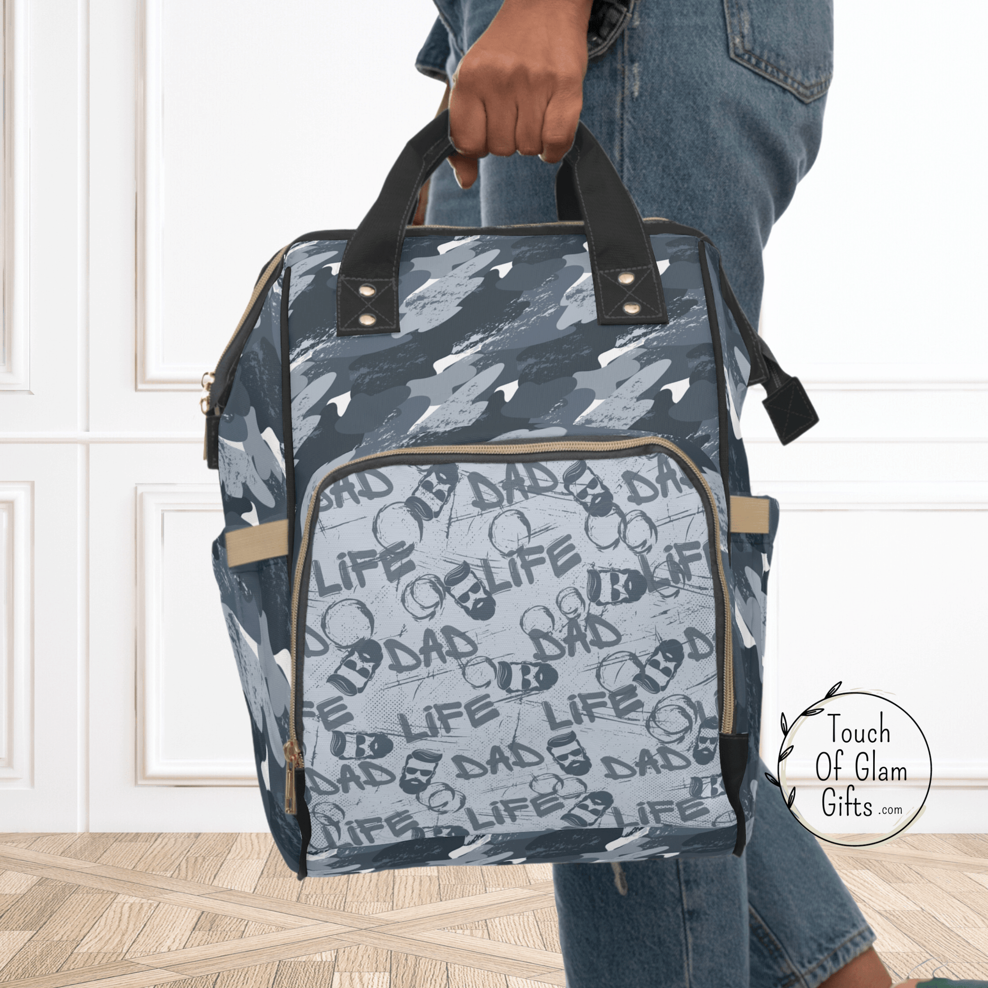 This blue camouflage diaper backpack was created just for dads. The front exterior, zippered pocket has the dad life, graffiti design that blends with the blue camo. This backpack is shown with the top carrying handles.