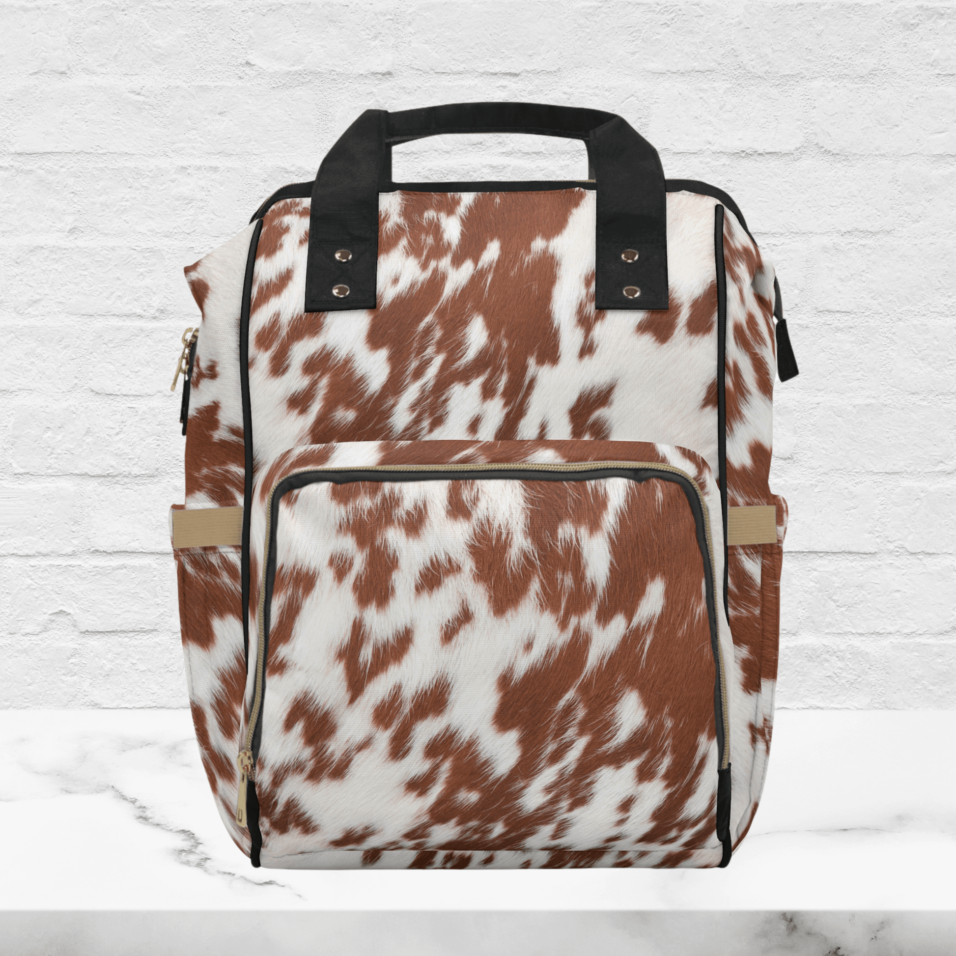 OUr rust and white colored cowhide print baby bag backpack can be ordered without the monogram initials.