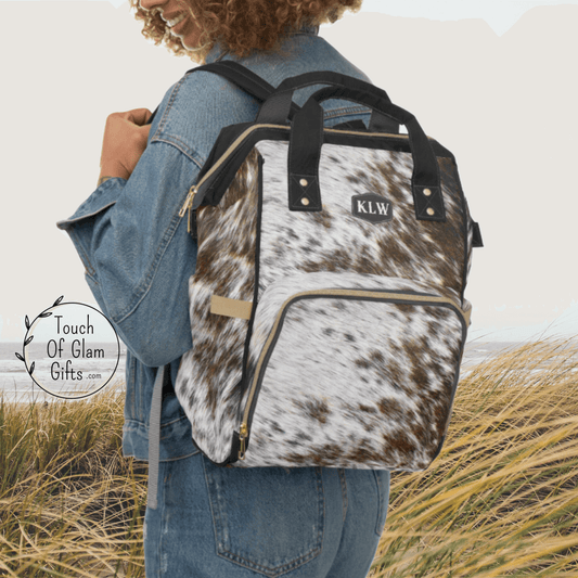 Our cowhide diaper backpack is shown with the monogram initials on a model wearing this as a backpack. This makes the perfect baby shower personalized gift for the western mom to be.