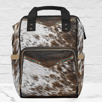 The front of the plain cowhide backpack shows the attention to detail on our fancy backpack. The brown leather is on the top and pocket with a fancy cowgirl turquoise band on the edge.