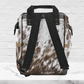 The back of our multipurpose airport backpack for women shows the beautiful cowhide print with black padded adjustable straps and black piping around the edges .