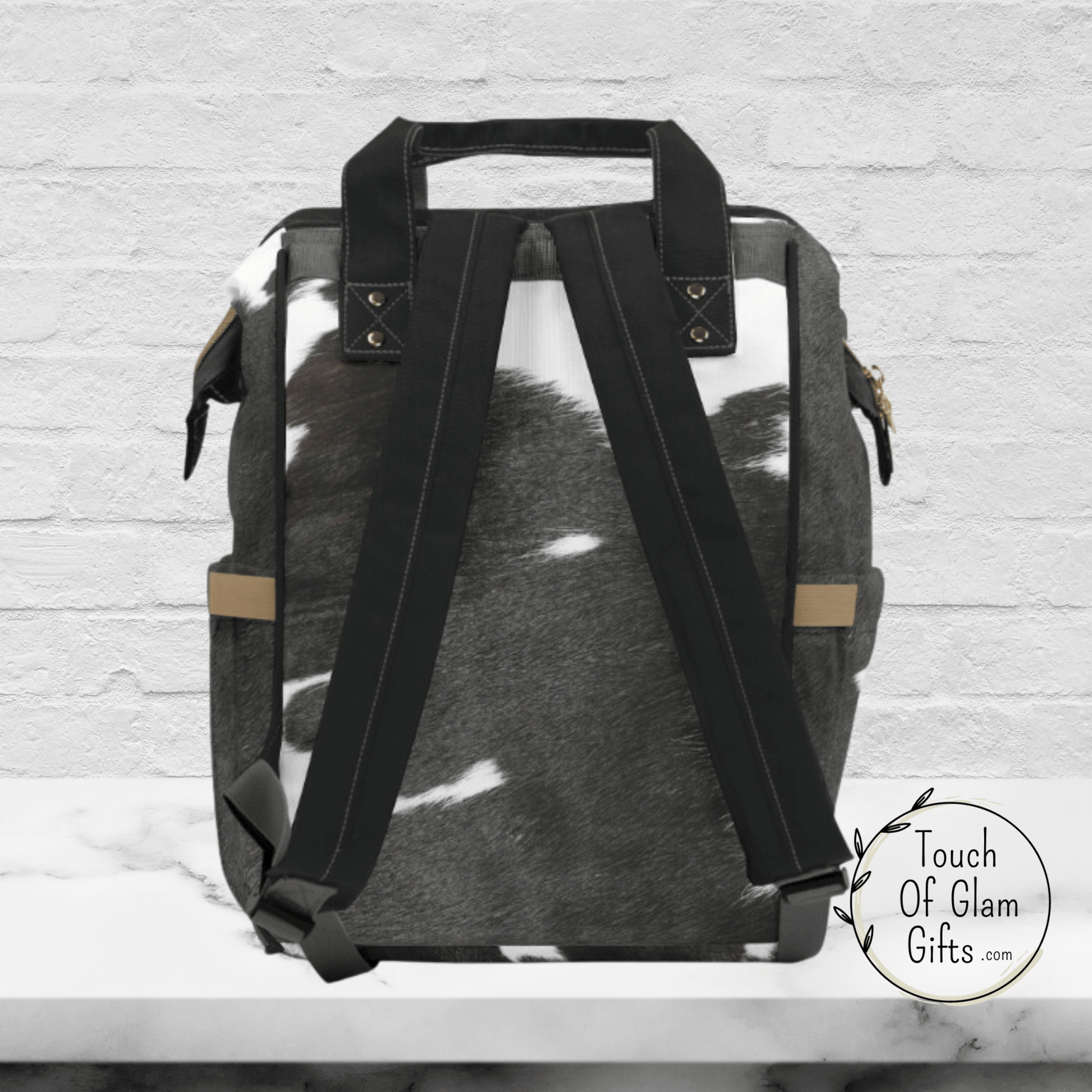 THe back side of our diaper bag backpack shows the black padded shoulder straps and black carrying handles.