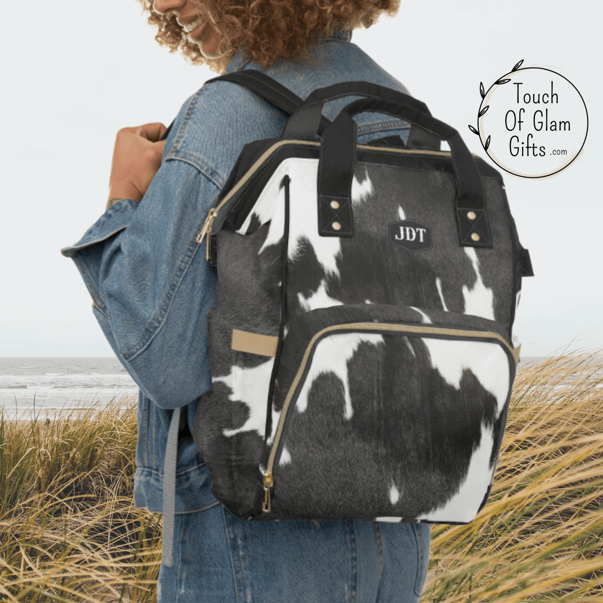our black and white cow print backpack looks great on this model with the padded shoulder straps and monogrammed initials.