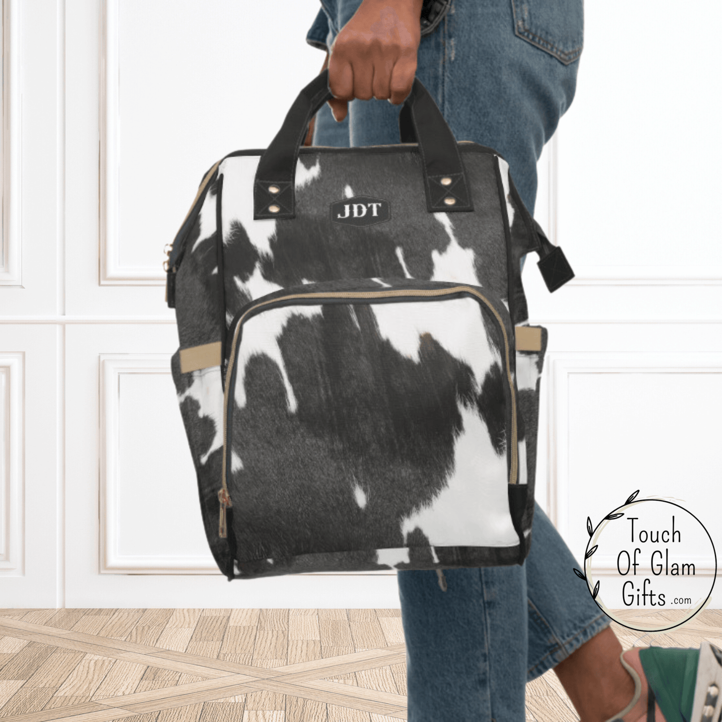 Our cowhide backpack can be carried with the comfortable handles. There is two zippered compartments on the outside and two pockets on each side.