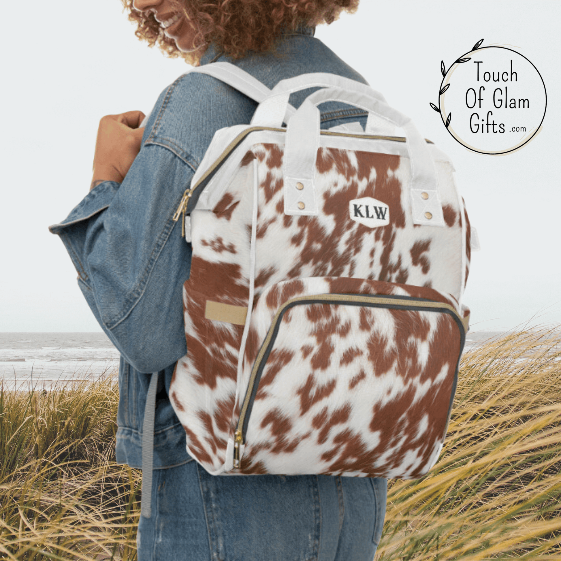 Our cow print backpack with personalization has white padded shoulder straps and white handles. THis bag makes a great baby shower gift.