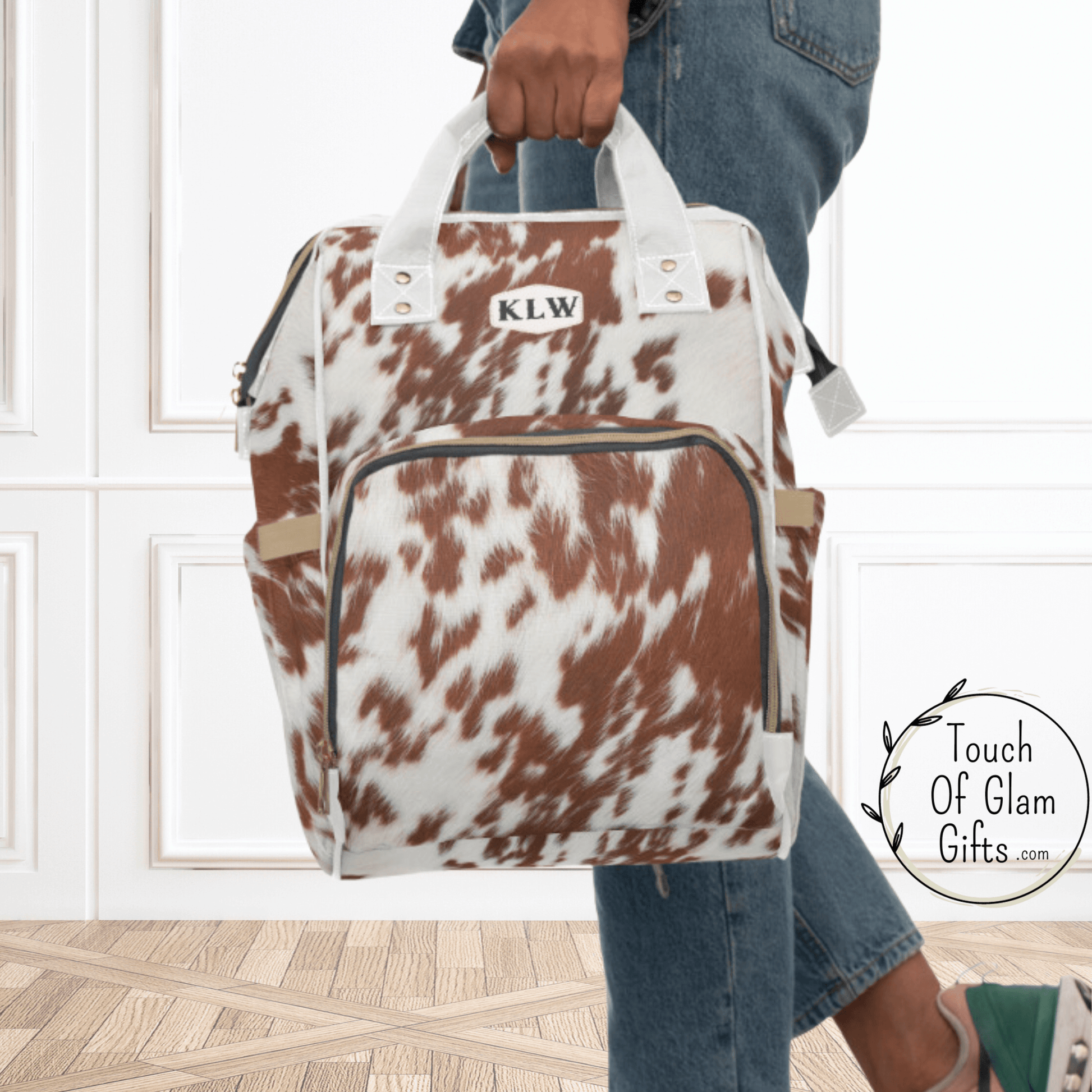 Our cowhide backpack shown being carried by the comfortable handles and with monogram initials. THis western bag is a great gift for bridesmades too. 