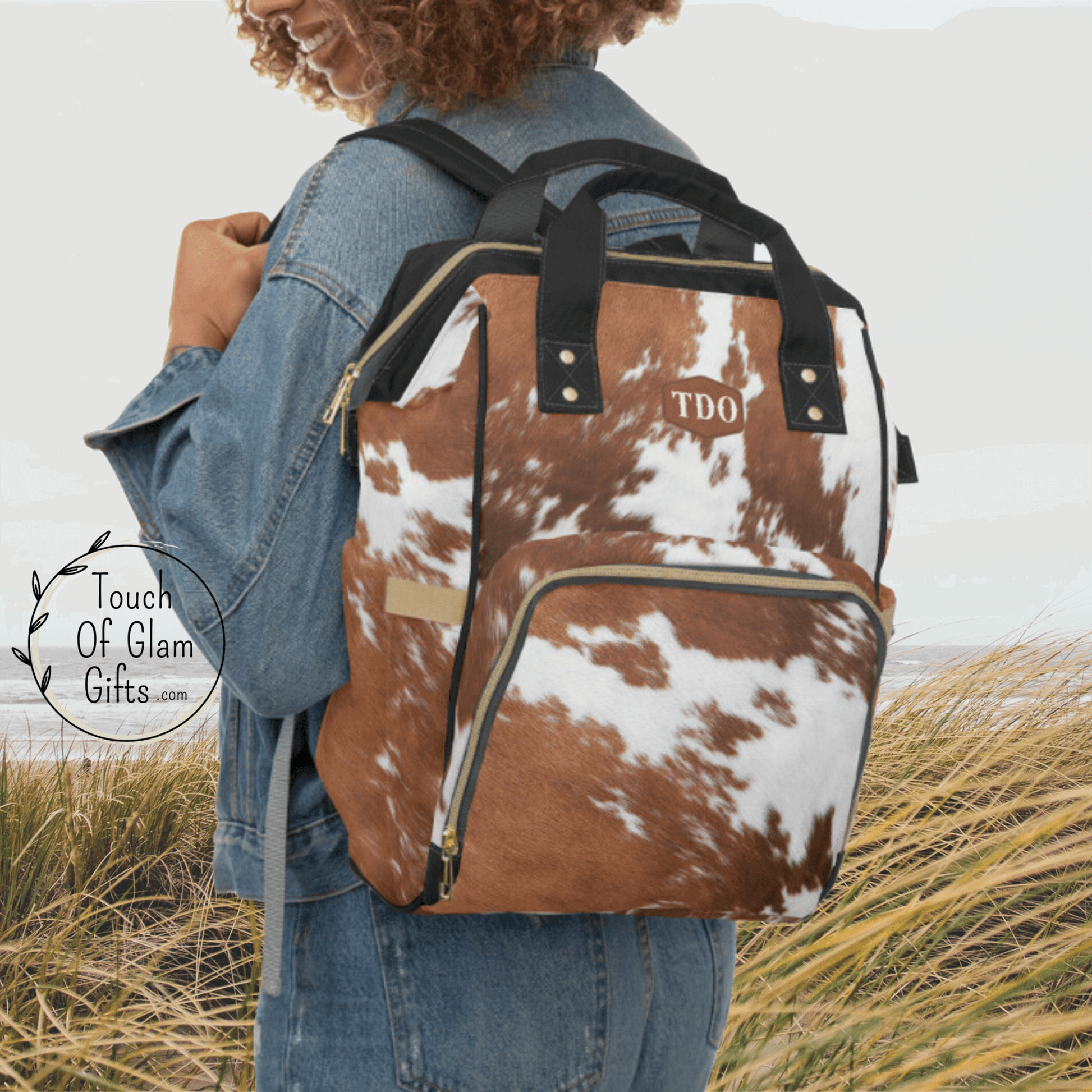 Our model is wearing the cowhide backpack over her shoulders to show the size of the personalized bag.