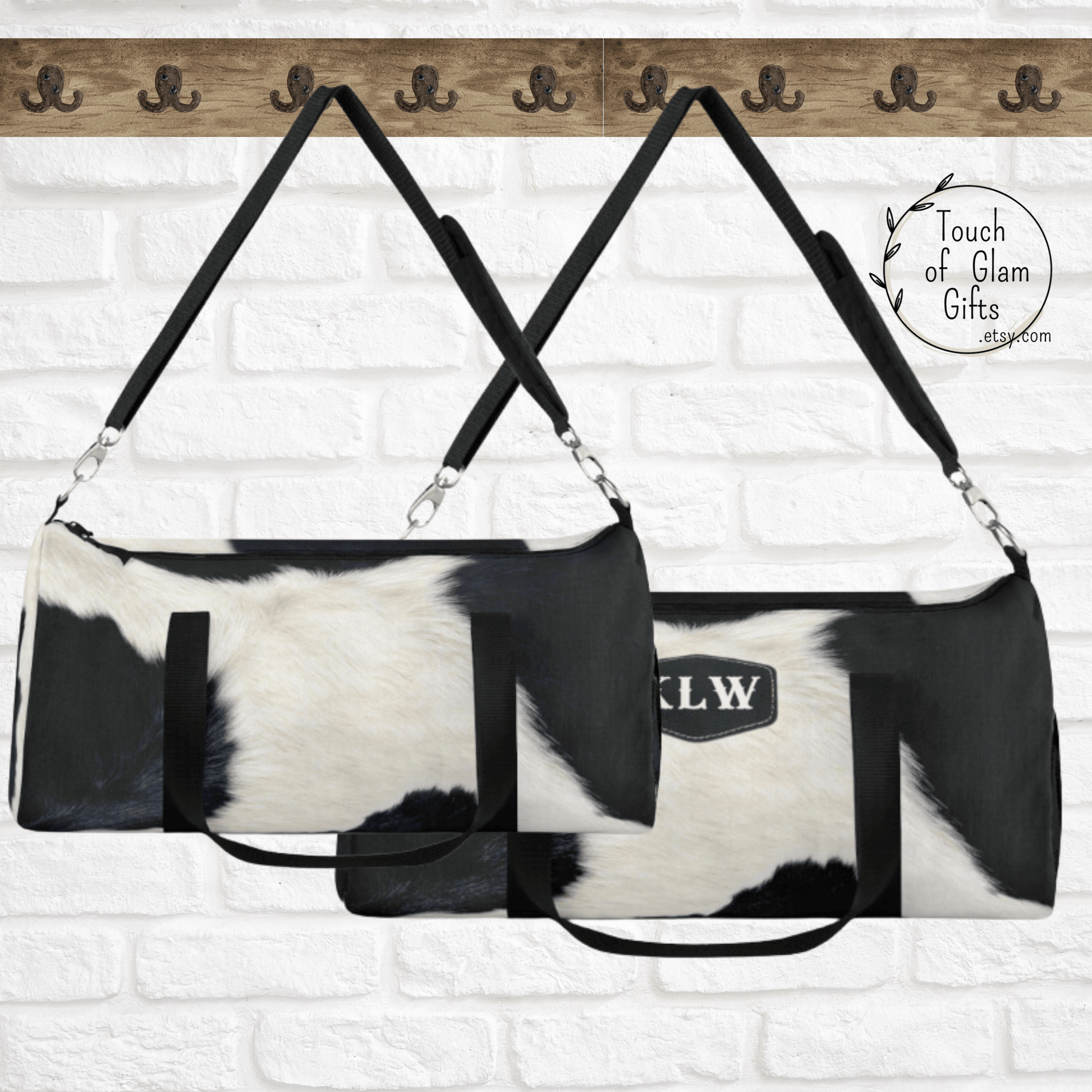 Our cowhide duffel bag is shown hanging with the padded shoulder strap on a hook and the large is monogrammed and the small duffel bag is plain cowhide.