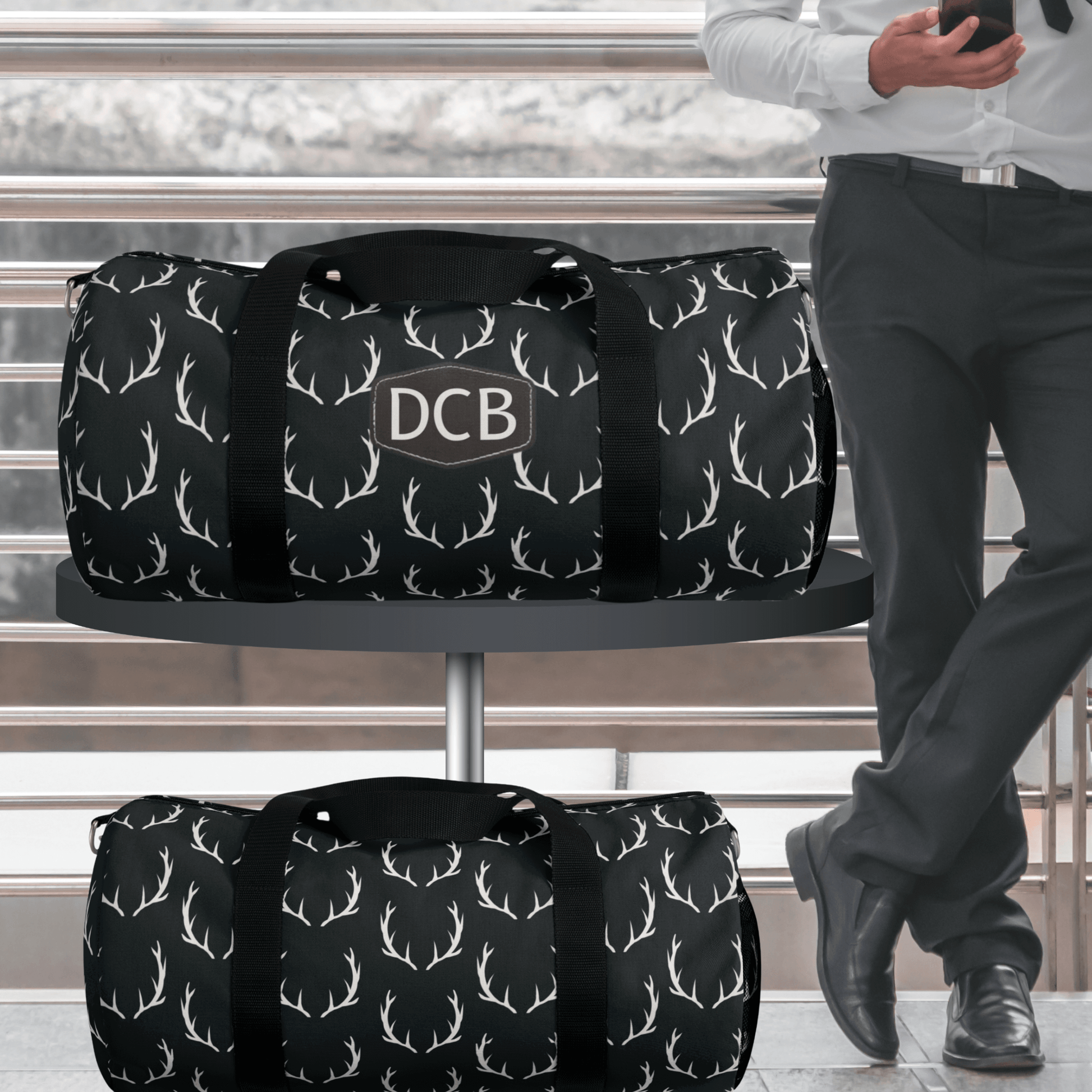 Our mens black duffel bag for deer hunters is the perfect business travel bag for him. It has a sleek design with deer antlers on a black background and the monogrammed patch is brown. 