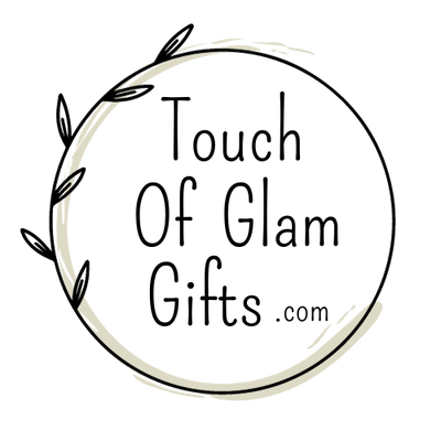 Touch of glam gifts dot com logo is a black circle with a tan swish and the words in the middle.