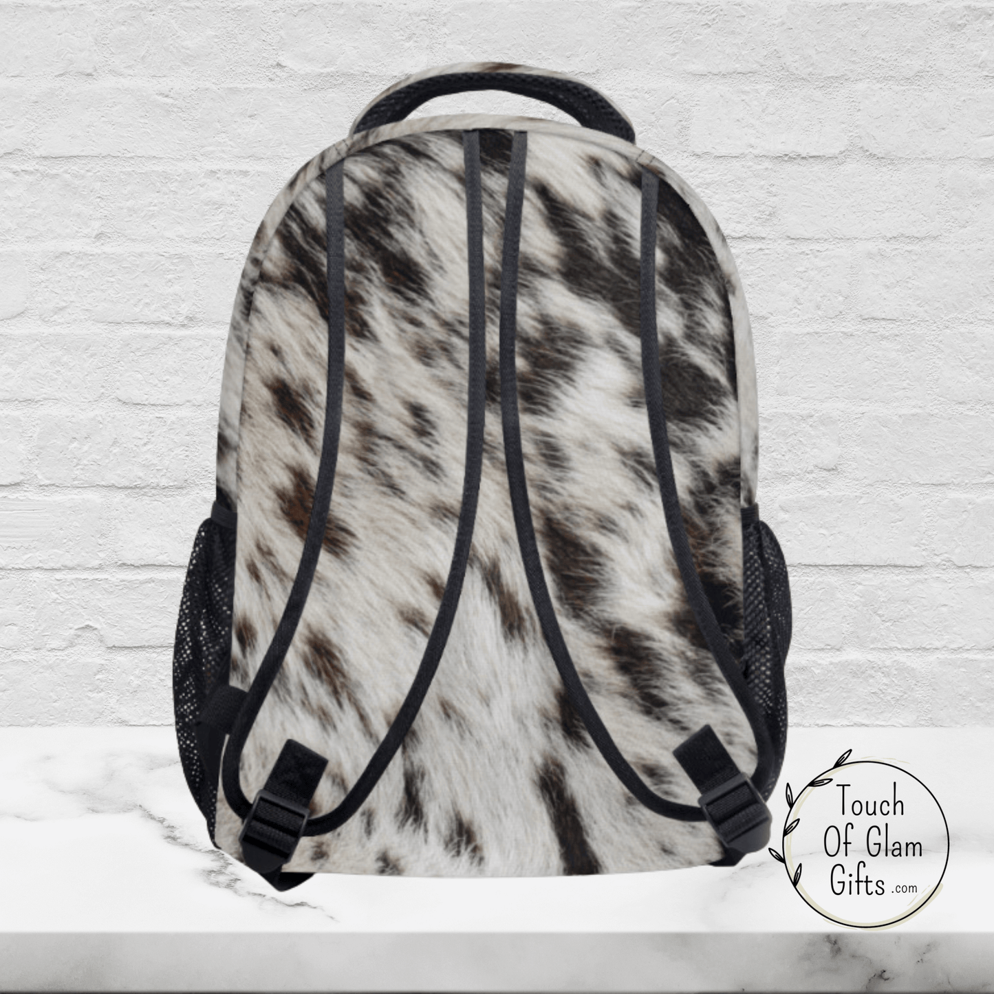 The backside of our cow print bag shows cow print on all sides of the bag even the straps.