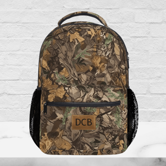 Up close view of the camo backpack shows the monogram front pocket and the padded handle and zippered pocket.