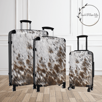 Our brown and off white cowhide luggage set showing 3 sizes of suitcases. Large suitcase, medium suitcase and small suitcase.