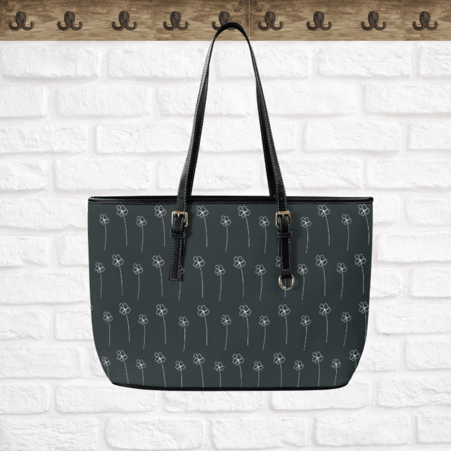 OUr faux leather tote bag has a black background with tiny off-white flowers.